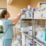 Side view of female nurse working in storage room of cancer hospital